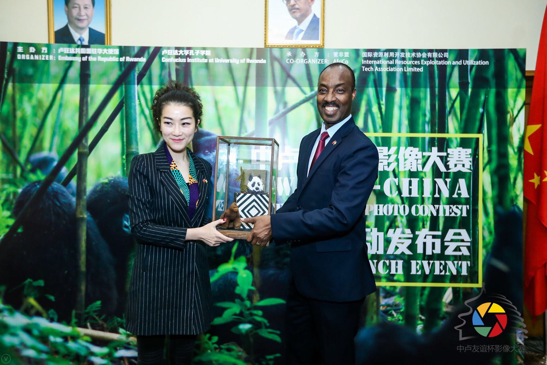盧旺達(dá)共和國駐中國大使查爾斯&bull;卡勇加閣下（右）向&ldquo;中盧友誼杯&rdquo;影像大賽承辦方愛非盟(AfriCo)創(chuàng)始人李青女士（左）互贈禮物